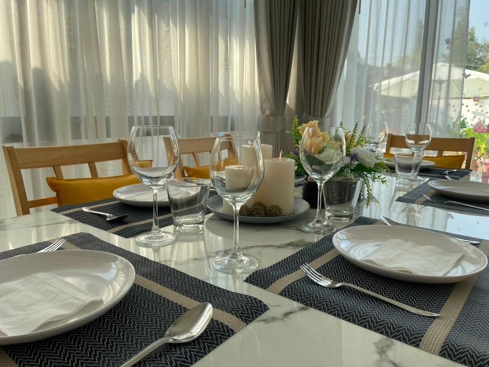 The dining table set for a meal, with candles and flowers