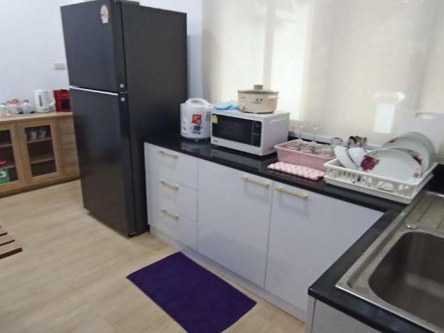The indoor kitchen with fridge, microwave and rice cooker